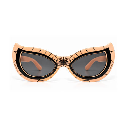 Spider-themed cat-eye sunglasses with a peach-colored frame featuring black web patterns and a spiderweb design at the bridge, paired with dark lenses.
